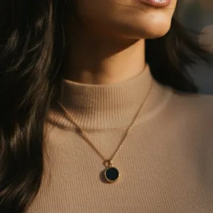 collier connecté doré avec résine noire porté par une femme