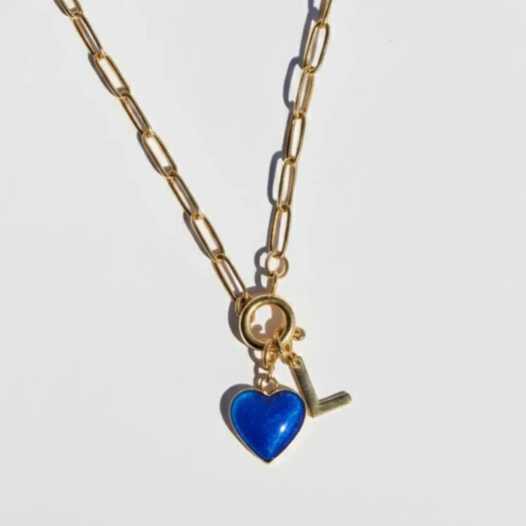 collier connecté en acier inoxydable doré avec un charm en forme de coeur et résine bleue avec une puce NFC et un charm initiale