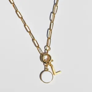 collier connecté en acier inoxydable doré avec un charm en forme de rond et résine blanche avec une puce NFC et un charm initiale