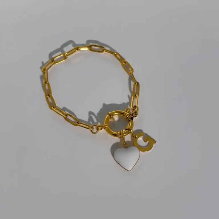 bracelet connecté en acier doré avec charm coeur noir et charm initial