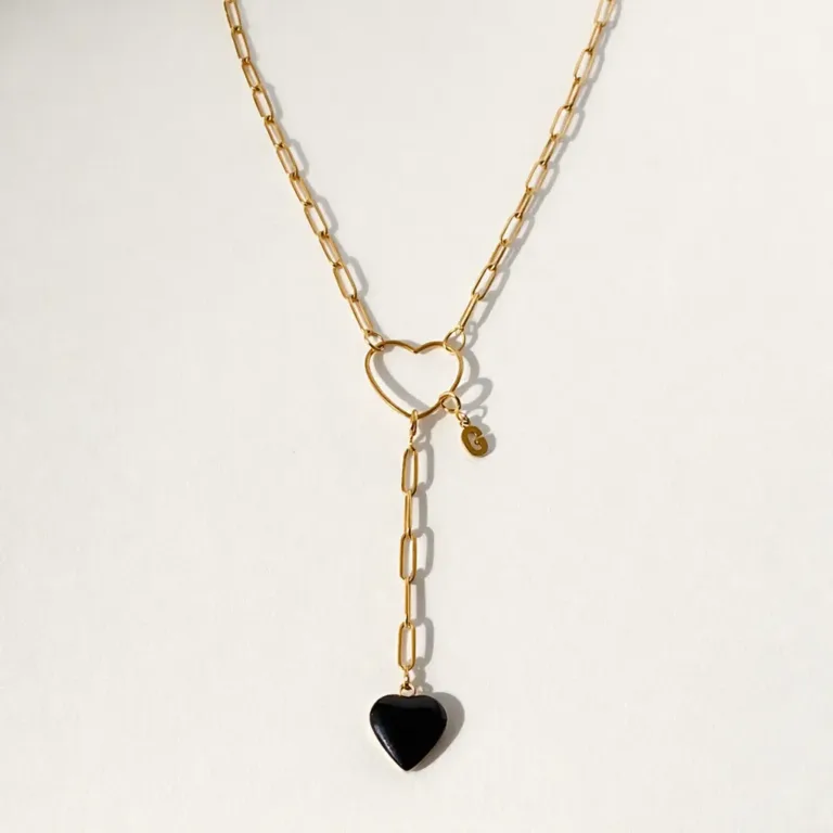 Collier personnalisable modulable en acier inoxydable doré avec un charm amovible noir en forme de coeur et un charm amovible initial G. Allure sautoir
