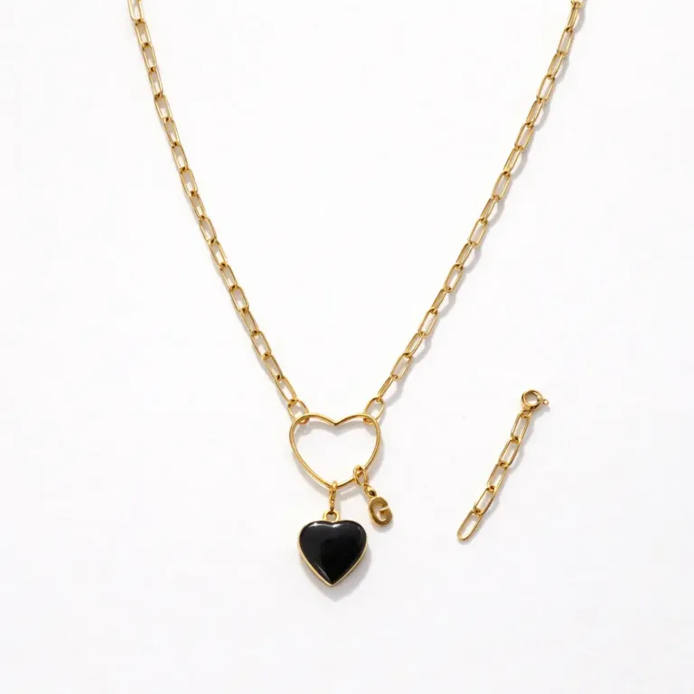 Collier personnalisable modulable en acier inoxydable doré avec un charm amovible noir en forme de coeur et un charm amovible initial G. Allure sautoir
