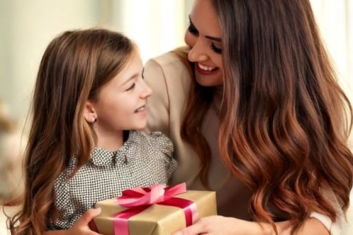 une petite fille qui offre un cadeau pour la fête des mères