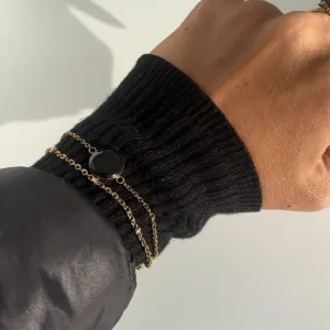 bracelet multi-rangs doré personnalisable avec puce NFC et capsule en résine noire porté par une femme