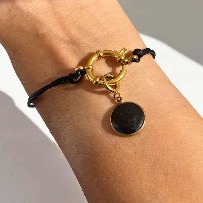 breloque pour bracelet dorée et résine noire portée
